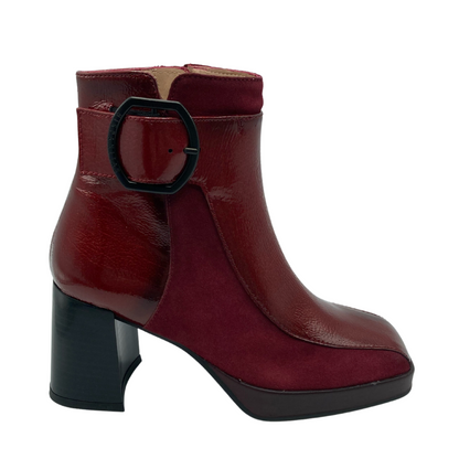 Side view of red leather ankle boot with black buckle detail and chunky black heel