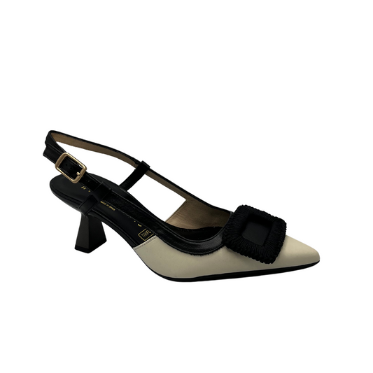 Angled view of black and ivory leather pump with flared heel and slingback strap. 