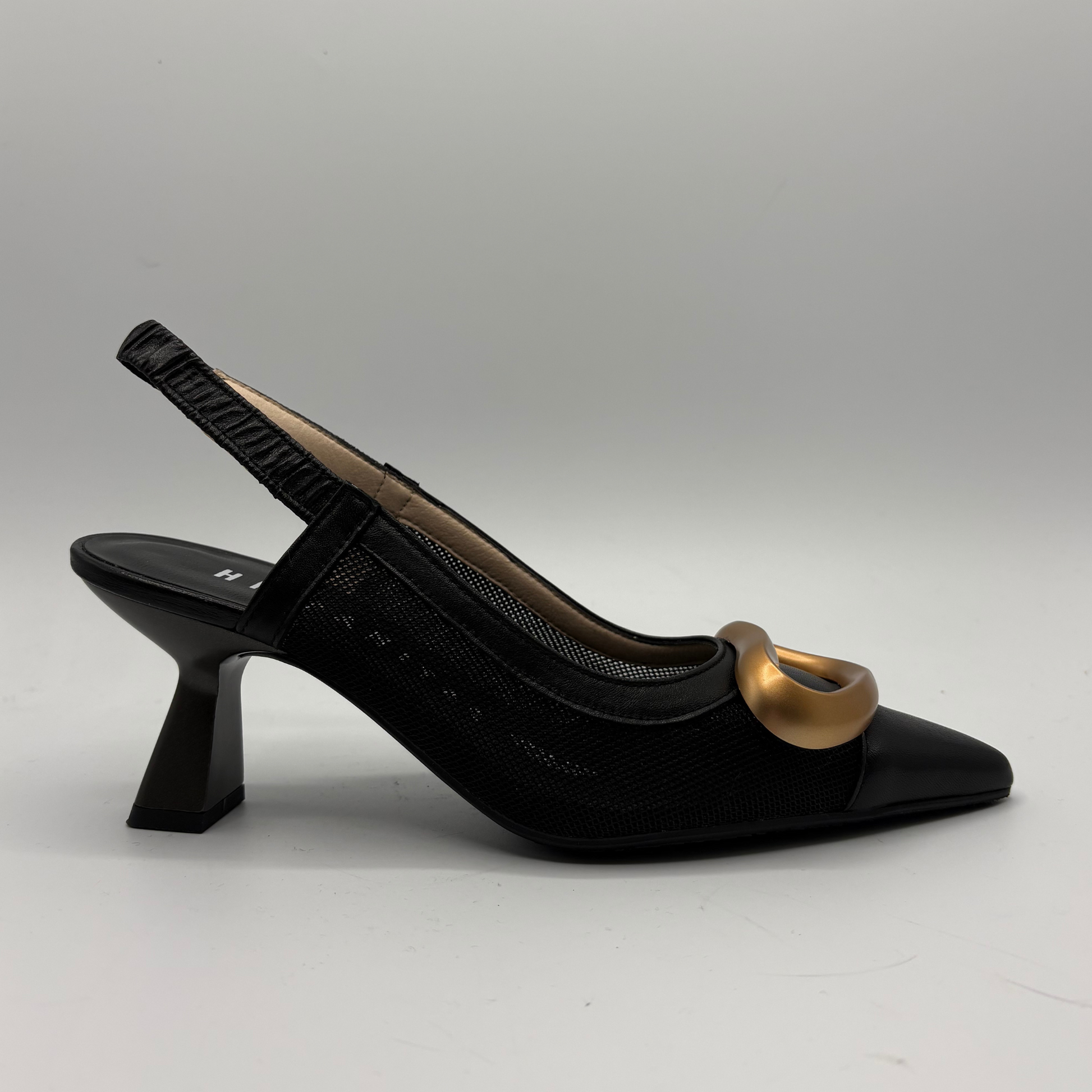 Black high-heeled shoe with a gold accent on a gray background