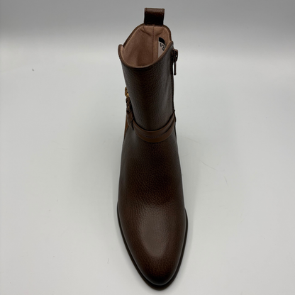 A dark brown pebbled leather ankle boot with a side buckle strap, shown from a front-facing perspective on a light gray background.