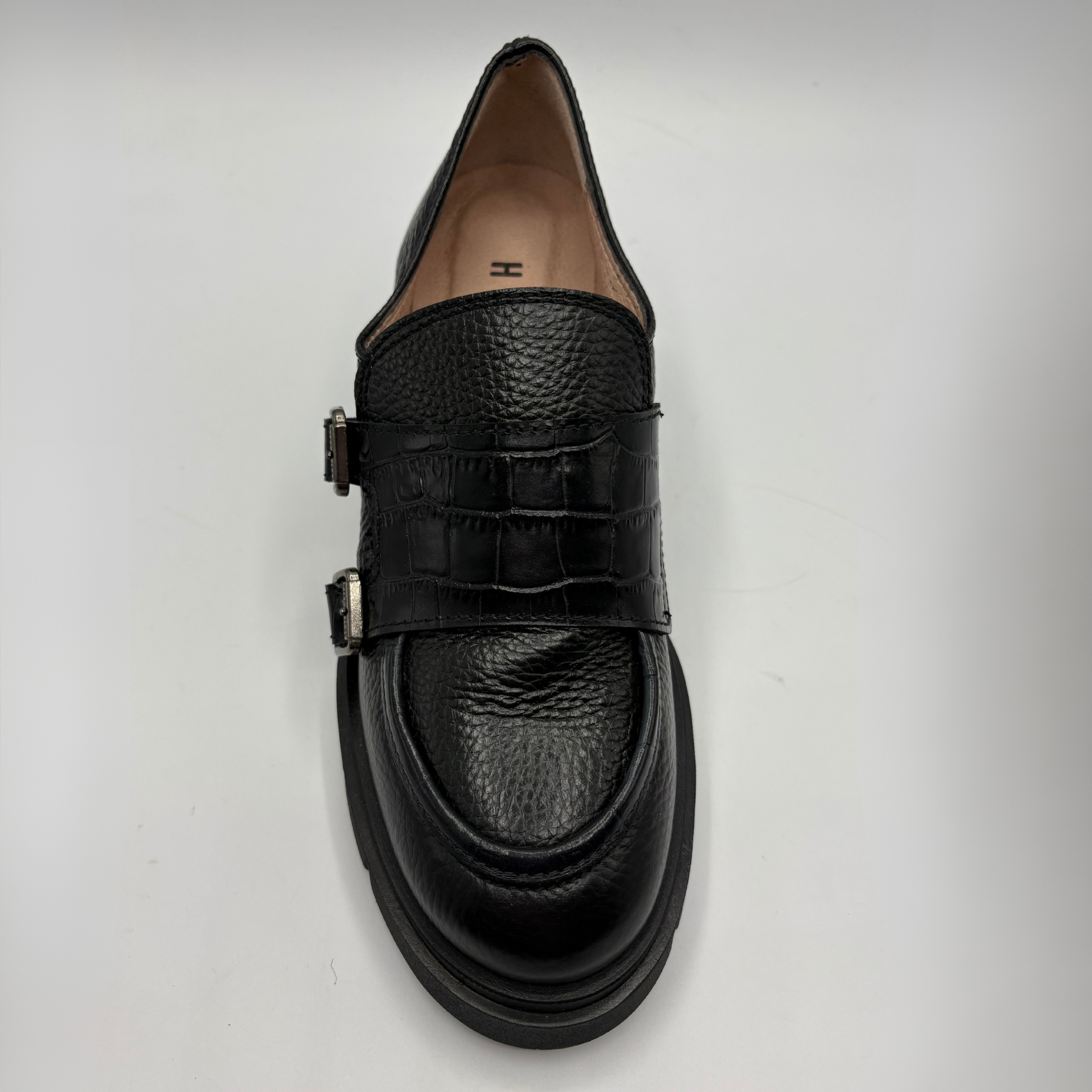 Top view of a black leather loafer with a chunky heel.