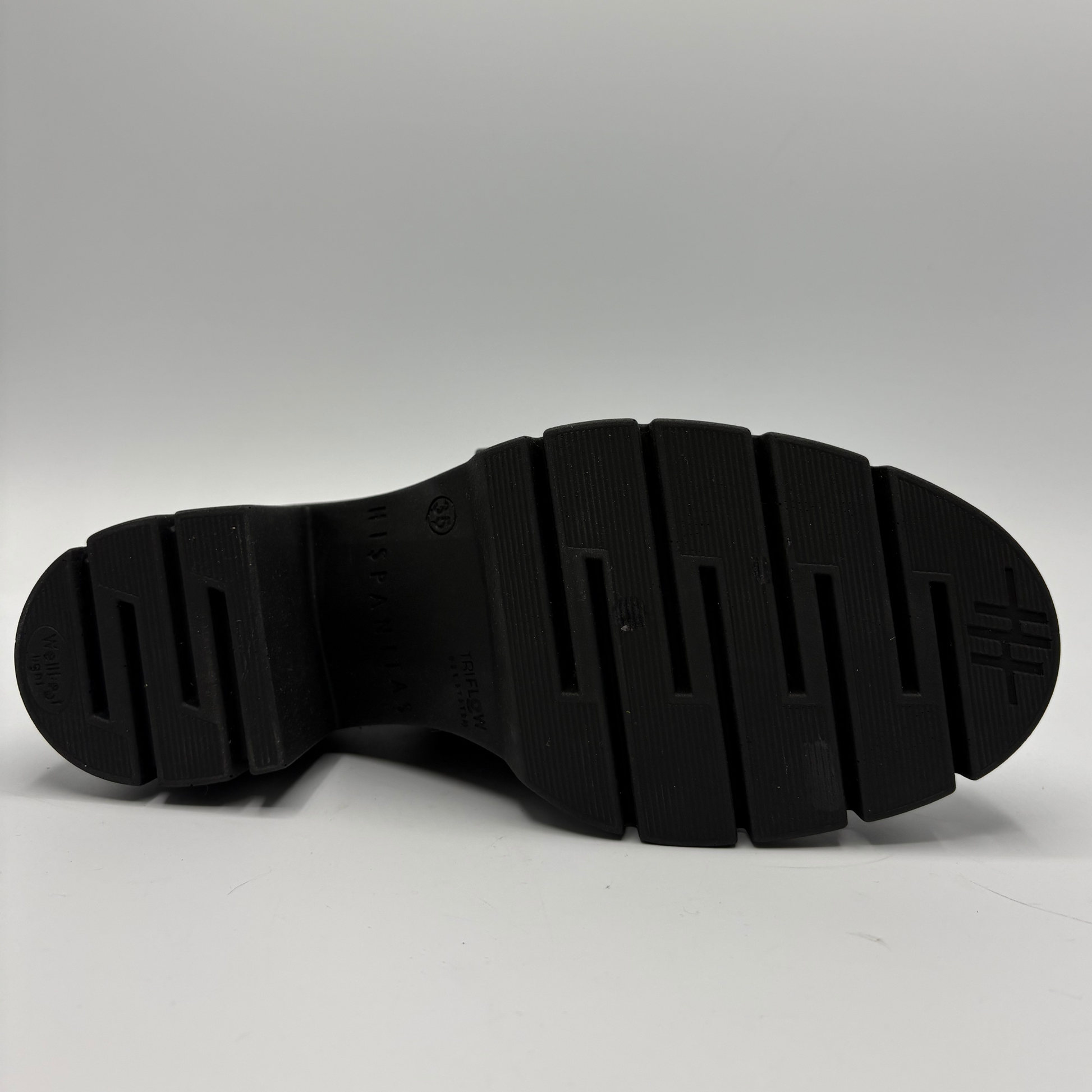 Bottom view of a black leather loafer with a chunky heel.