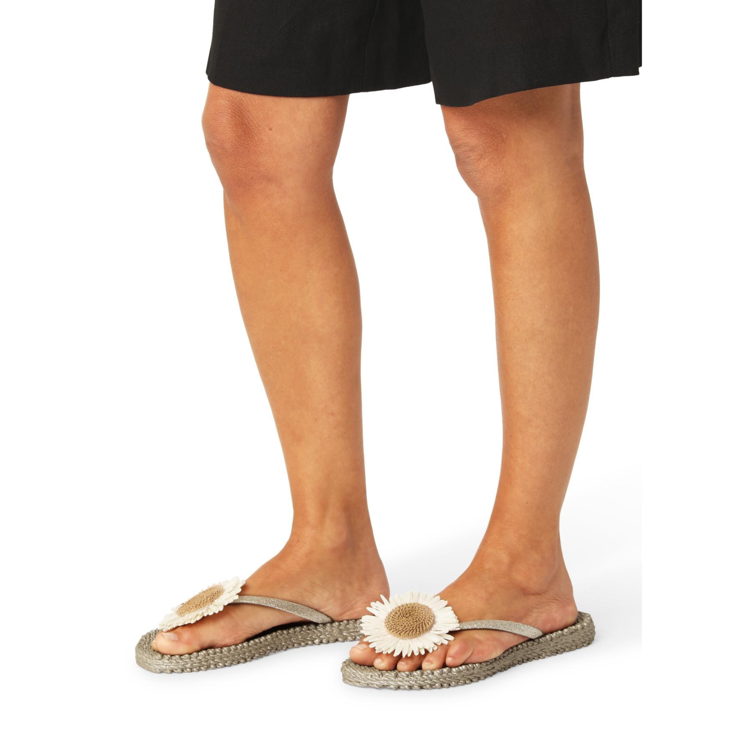 Person wearing sandals with floral designs on a white background