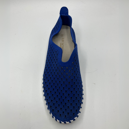 Top view of blue slip on shoe with an intricate laser cut upper and white rubber outsole.