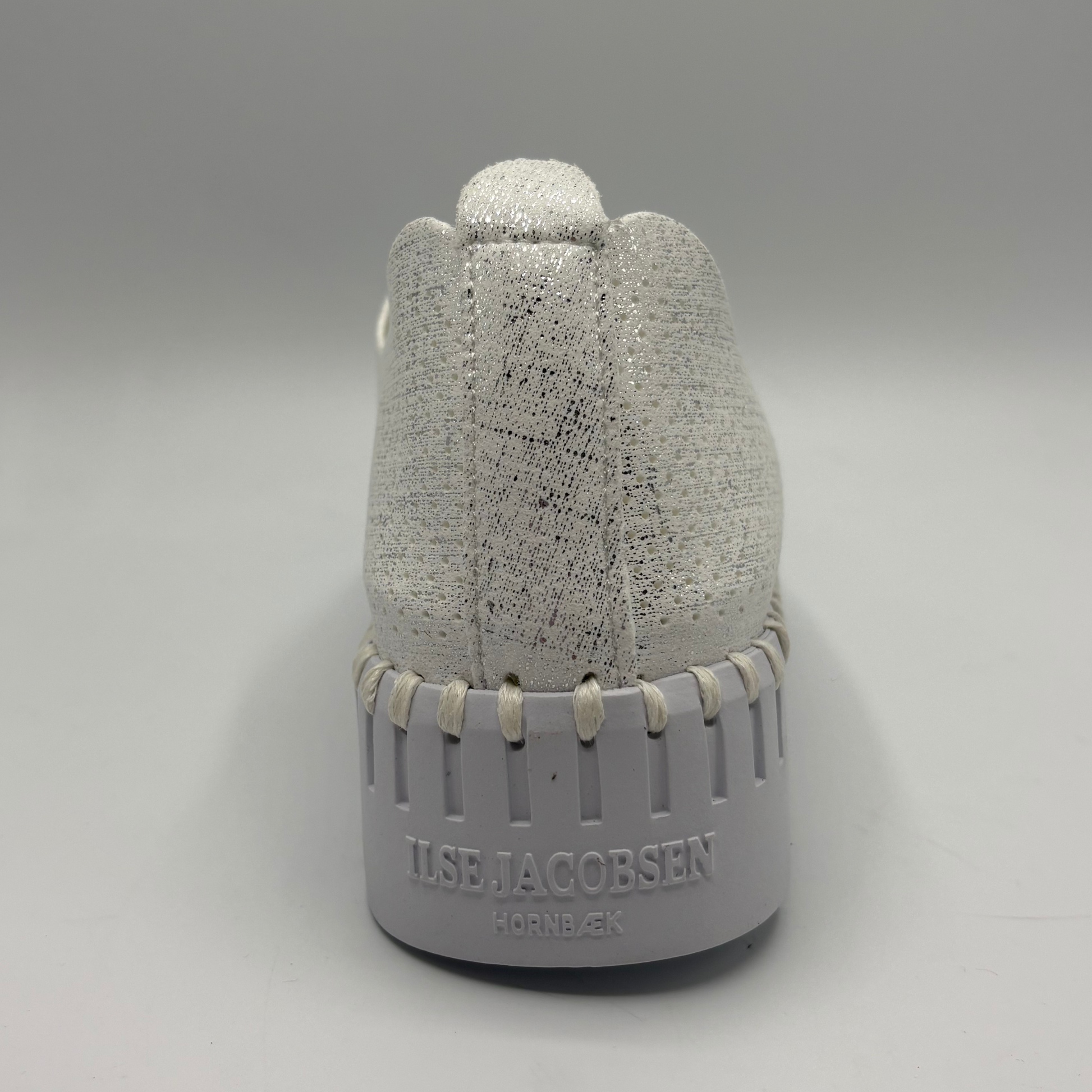 Gray textured bottle with 'Ilse Jacobsen' branding on a gray background