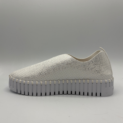 White slip-on sneaker with a thick gray sole on a light gray background