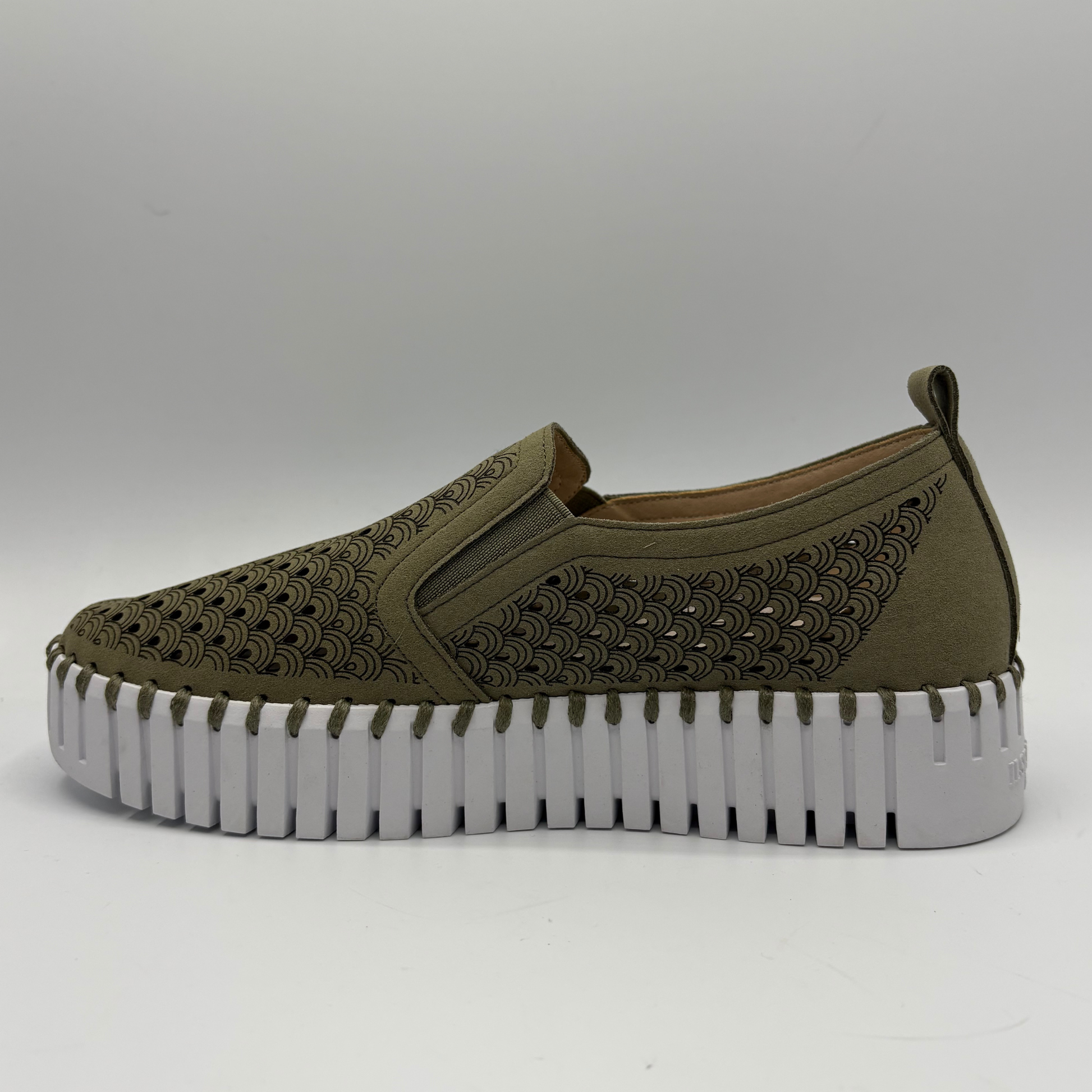 Green slip-on shoe with a thick white sole on a gray background