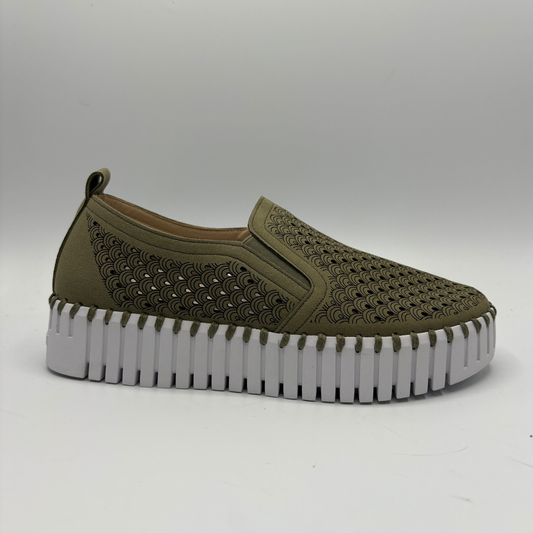 Green slip-on shoe with a thick white sole on a gray background