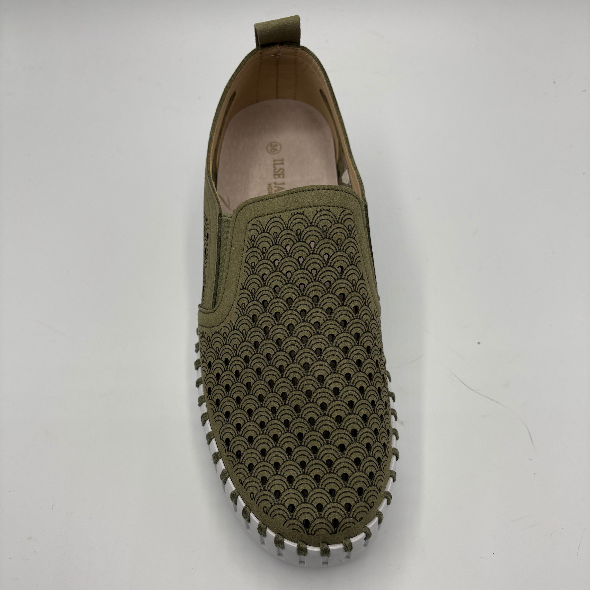 Green slip-on shoe with textured sole on a white background