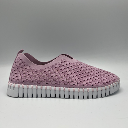 Right facing view of bubble pink slip on shoe with an intricate laser cut upper and white rubber outsole.