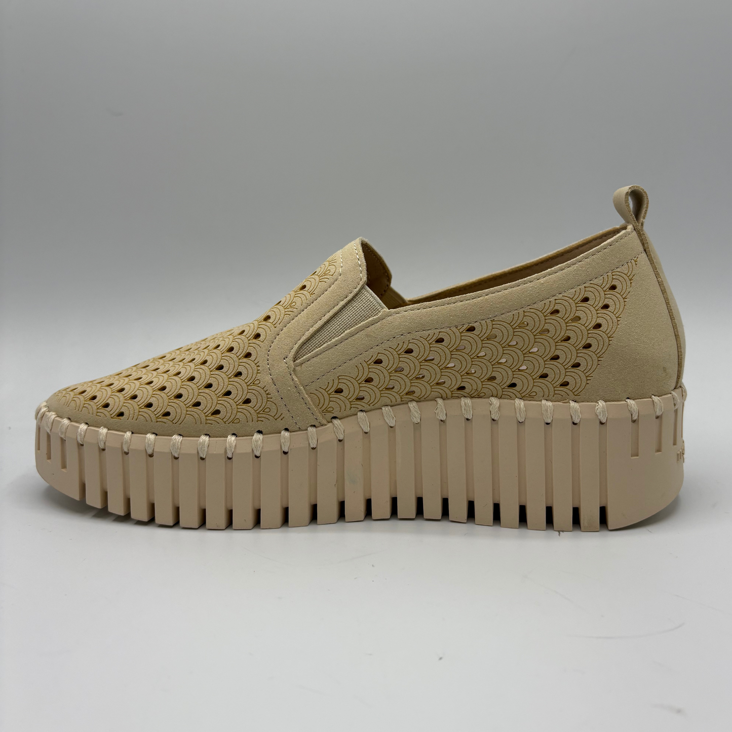 Beige slip-on shoe with textured sole on a white background