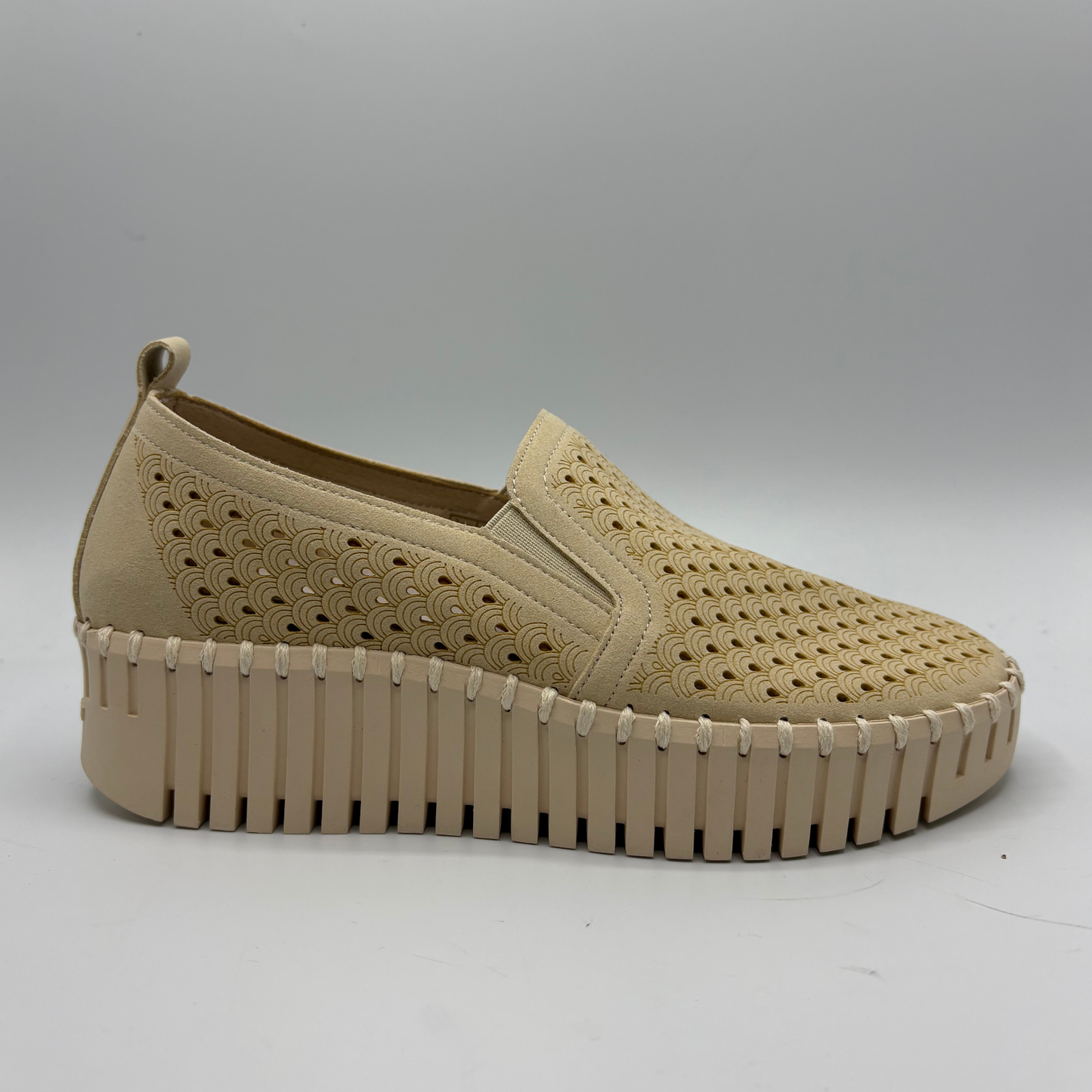 Beige slip-on shoe with textured sole on a light gray background