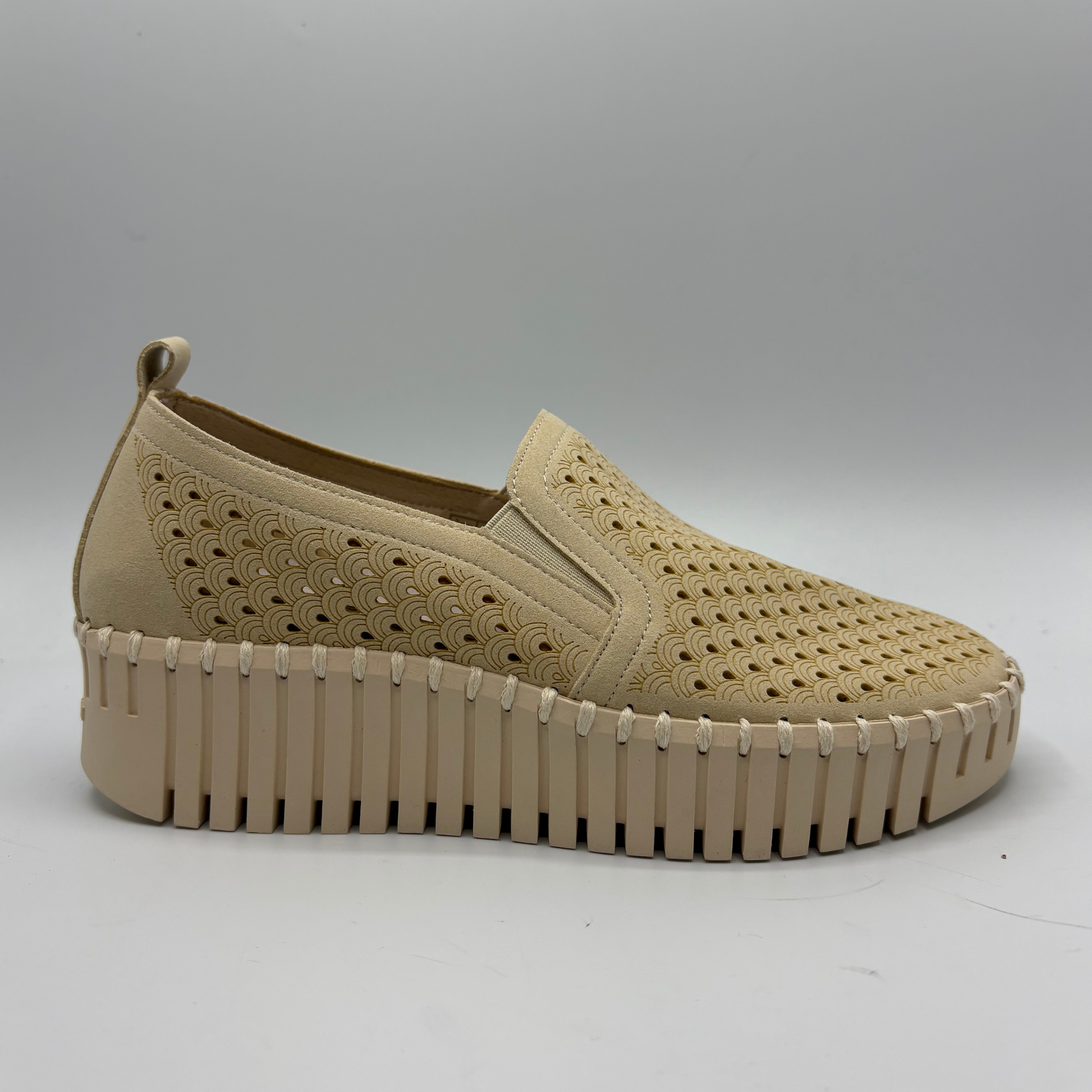 Beige slip-on shoe with textured sole on a light gray background