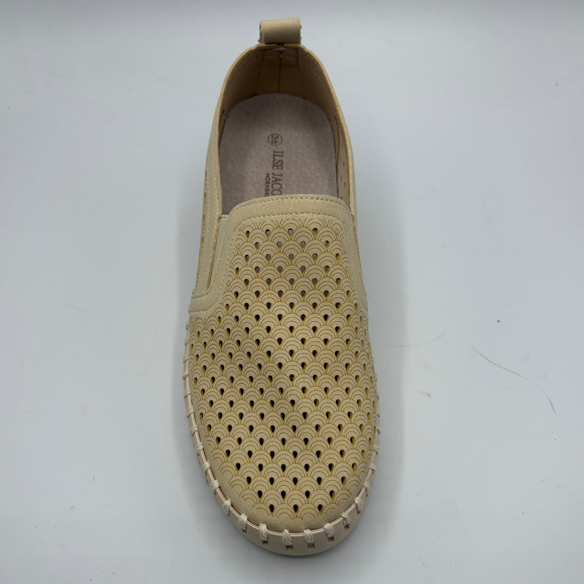 Beige slip-on shoe with perforated design on a white background
