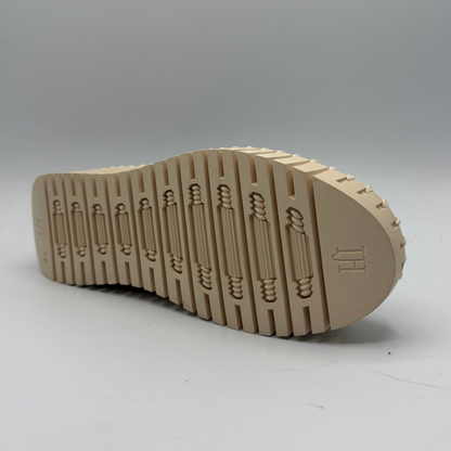 Beige shoe sole with tread pattern on a gray background