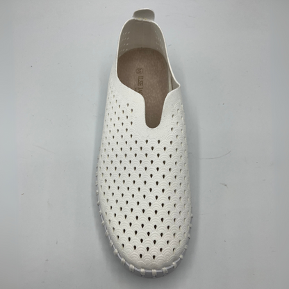 Top view of white slip on shoe with an intricate laser cut upper and white rubber outsole.