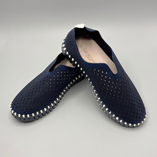 Pair of navy blue shoes with white stitching on a gray background