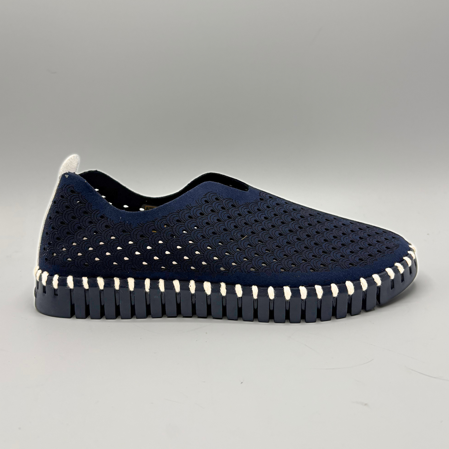 Navy slip-on shoe with white sole on a gray background