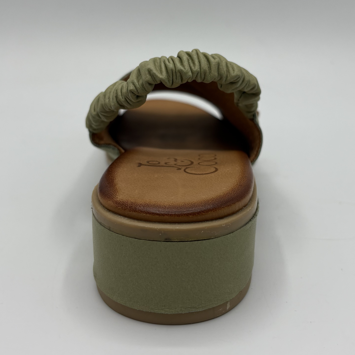 Green sandal with brown sole on a white background