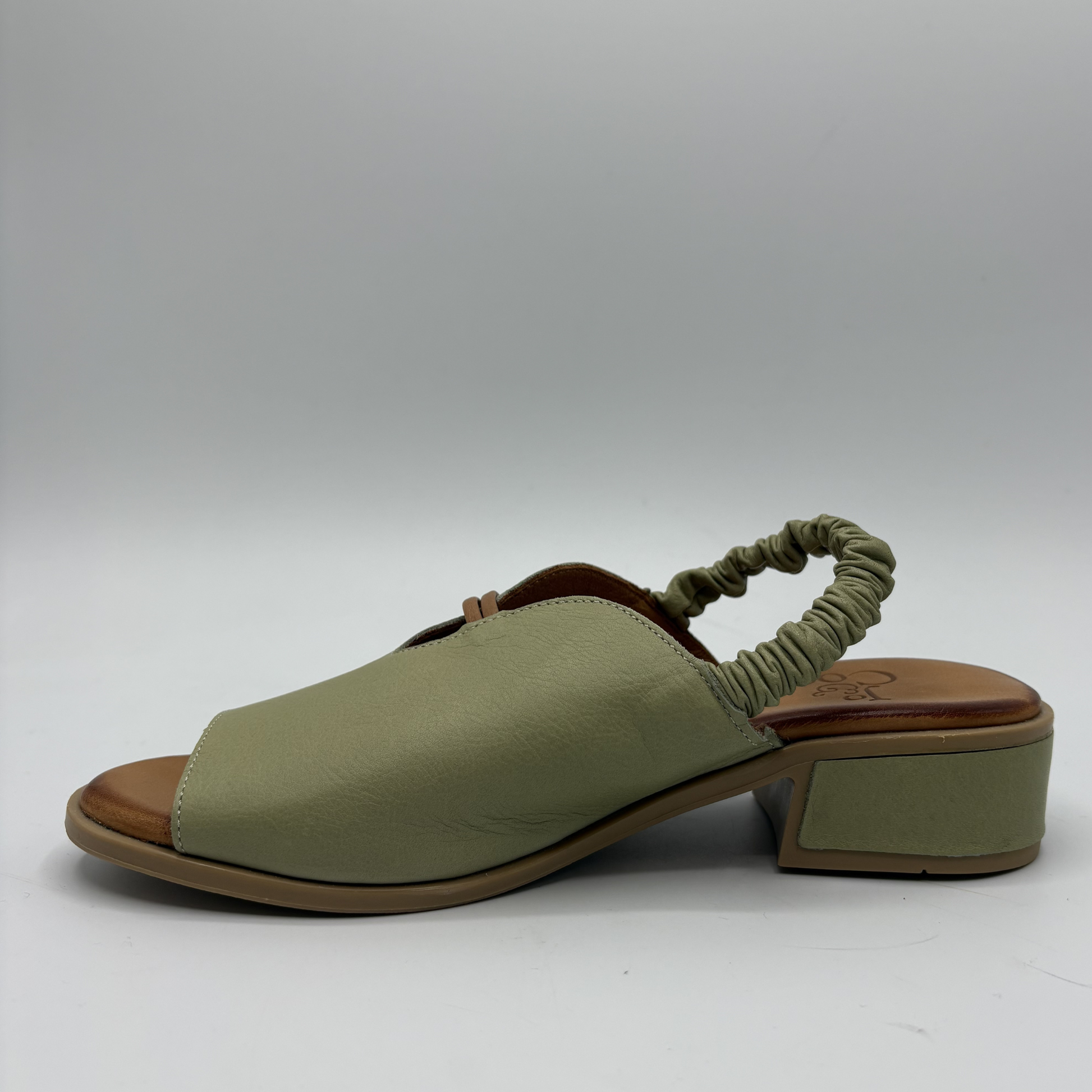 Green sandal with a block heel on a white background