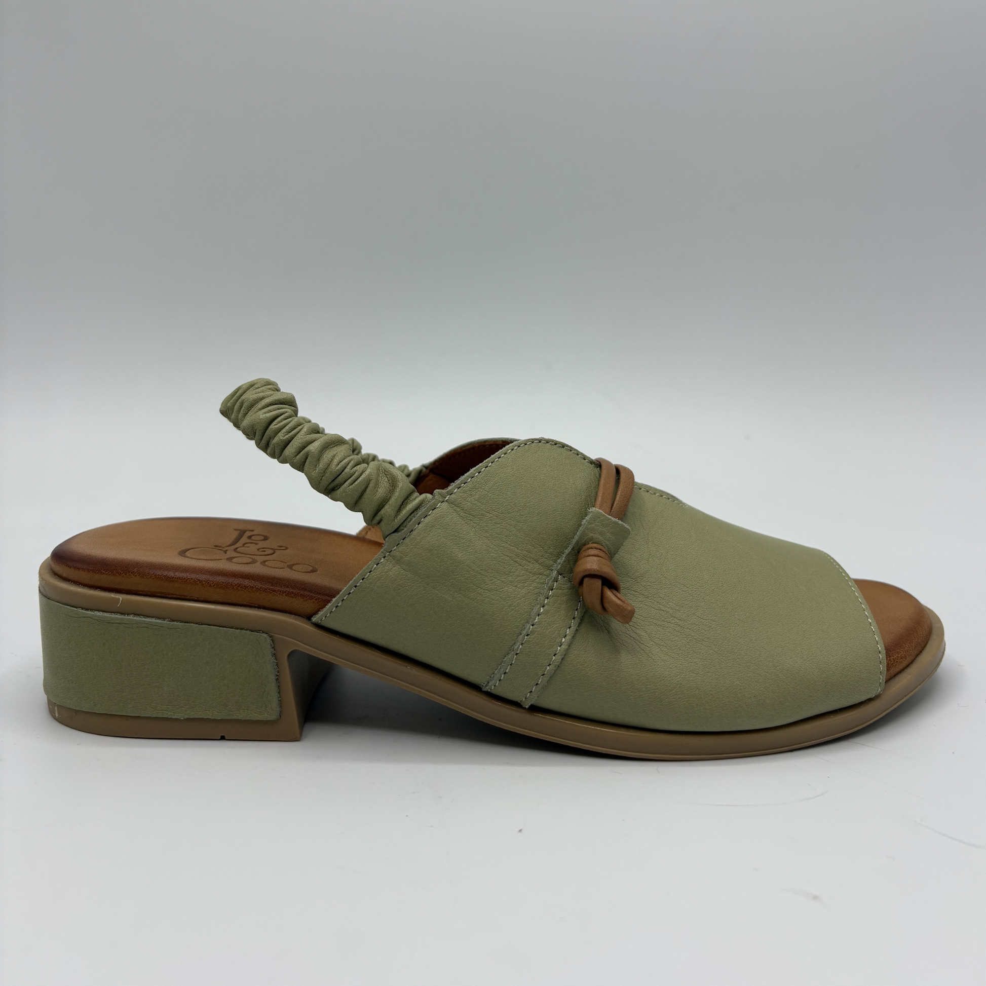 Green sandal with brown sole on a white background