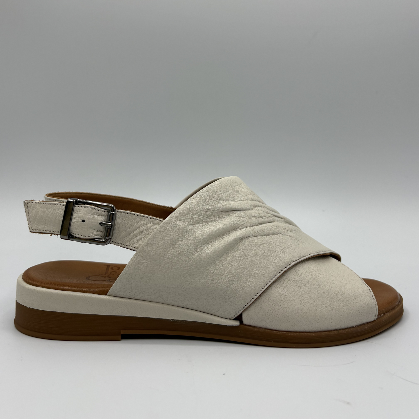 Beige sandal with brown sole on a gray background