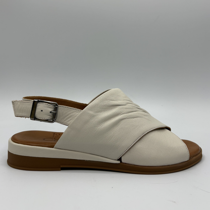 Beige sandal with brown sole on a gray background