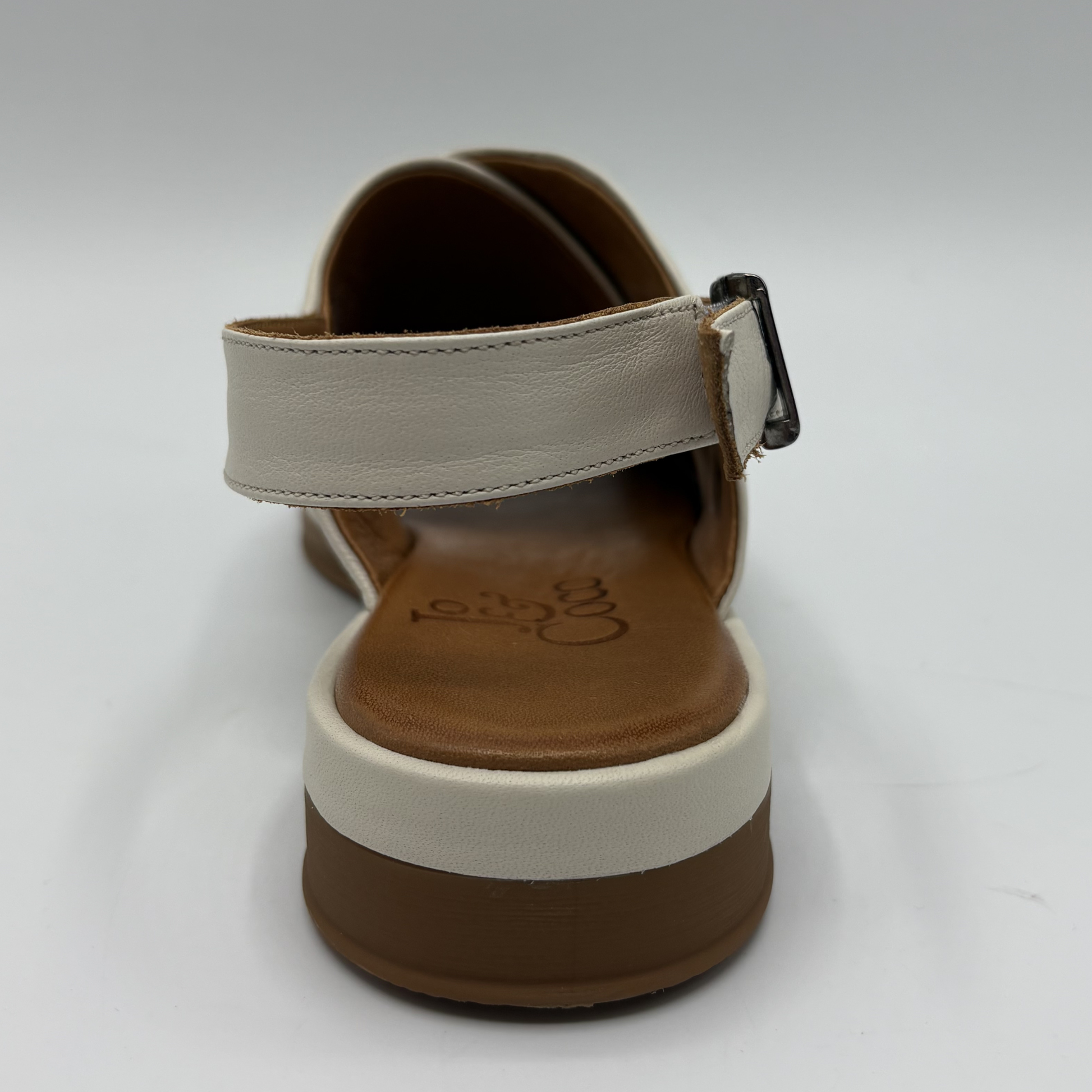 Single sandal with beige strap and brown sole on a white background