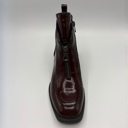 Front view of a deep red patent leather short boot with a front zipper closure