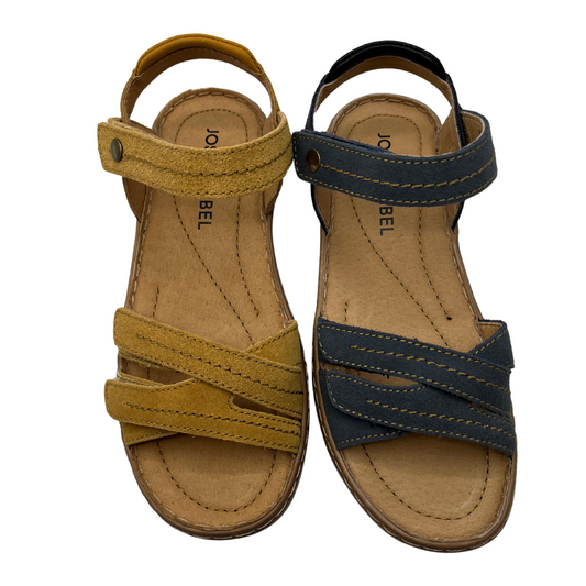 Top view of two sandals side by side. One tan coloured, one navy coloured. Both suede leather with multiple adjustable straps and open toe.