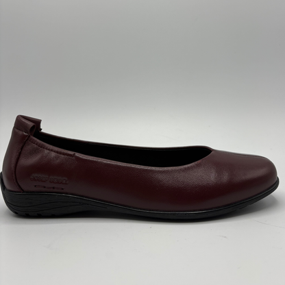 A single women's flat shoe in burgundy leather with a black sole, shown from a side profile view against a light gray background.