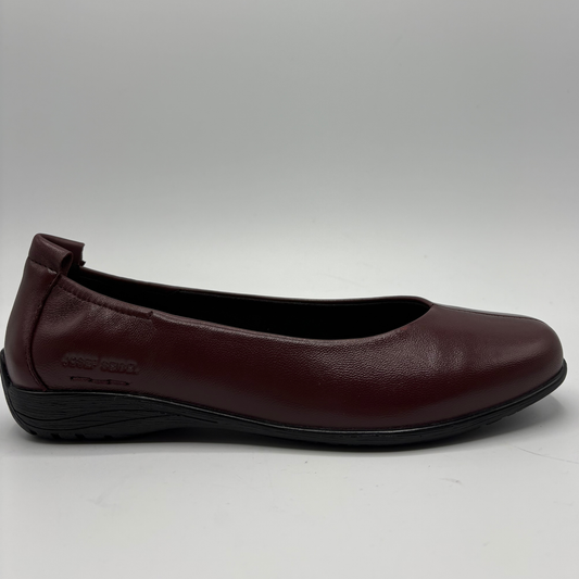A single women's flat shoe in burgundy leather with a black sole, shown from a side profile view against a light gray background.