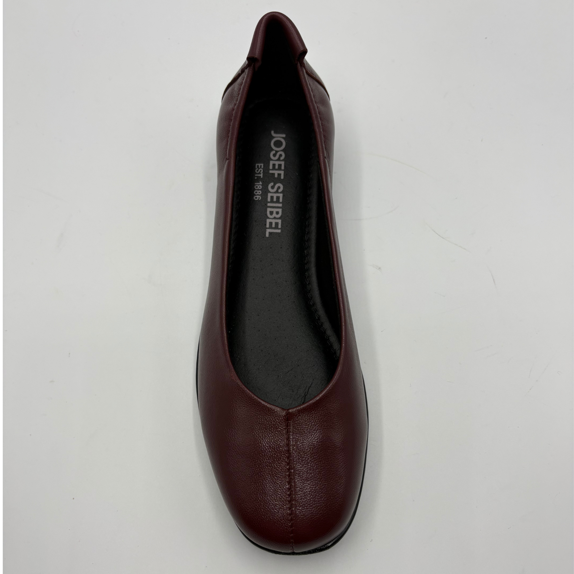 A single dark burgundy leather flat shoe shown from a top-down view on a light gray background. The brand name 'JOSEF SEIBEL' is printed in white on the black insole.