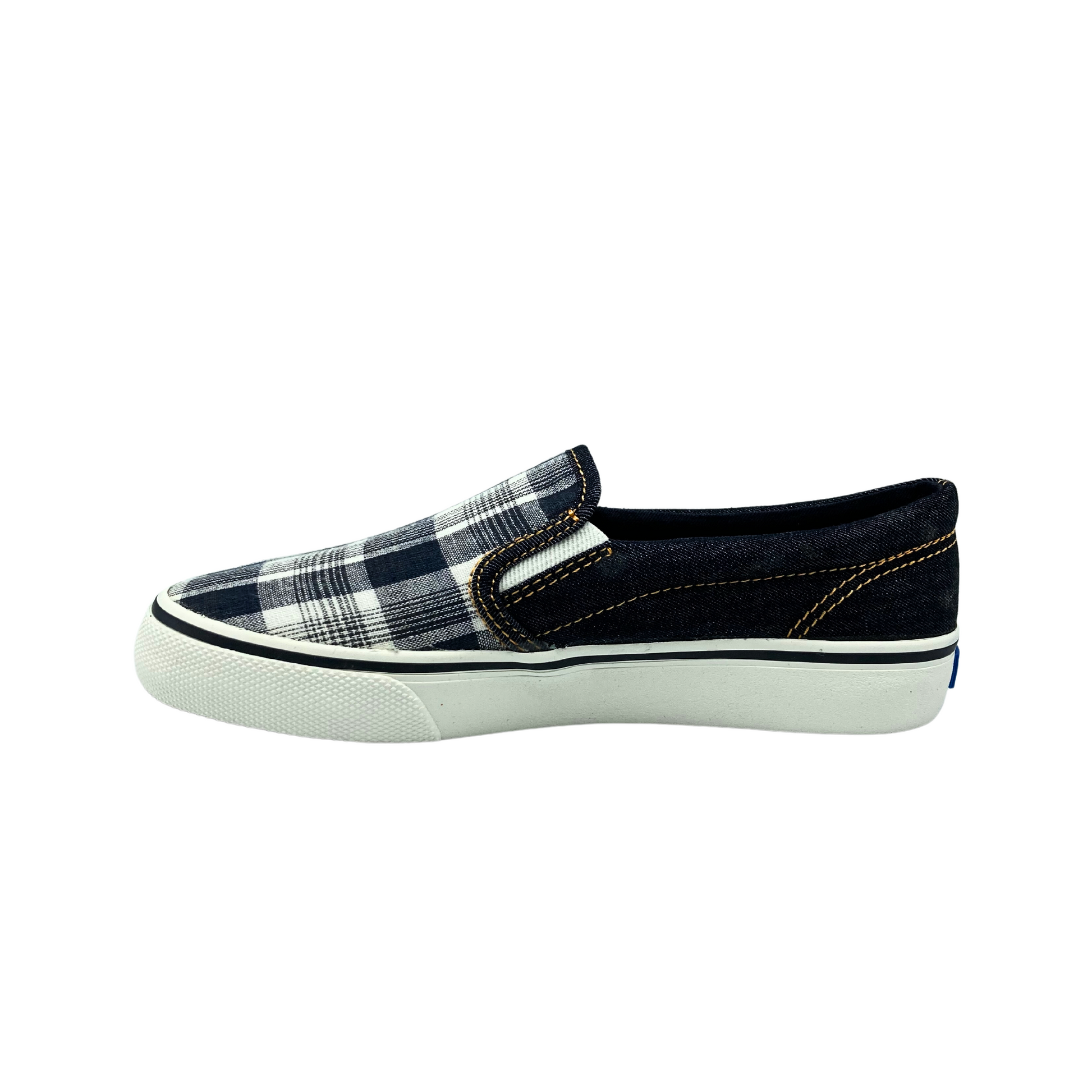 Inside view of a canvas slip on sneaker in a black denim plaid.  Sole is white rubber.  Two discrete elastic panels on either side at top of foot for easy on/off and more comfort when walking