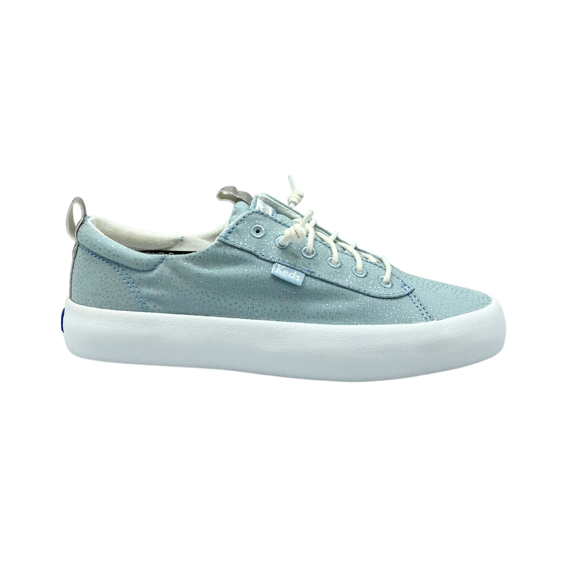 Outside  view of a canvas, slip on sneaker in a light blue/silver with a white rubber outsole