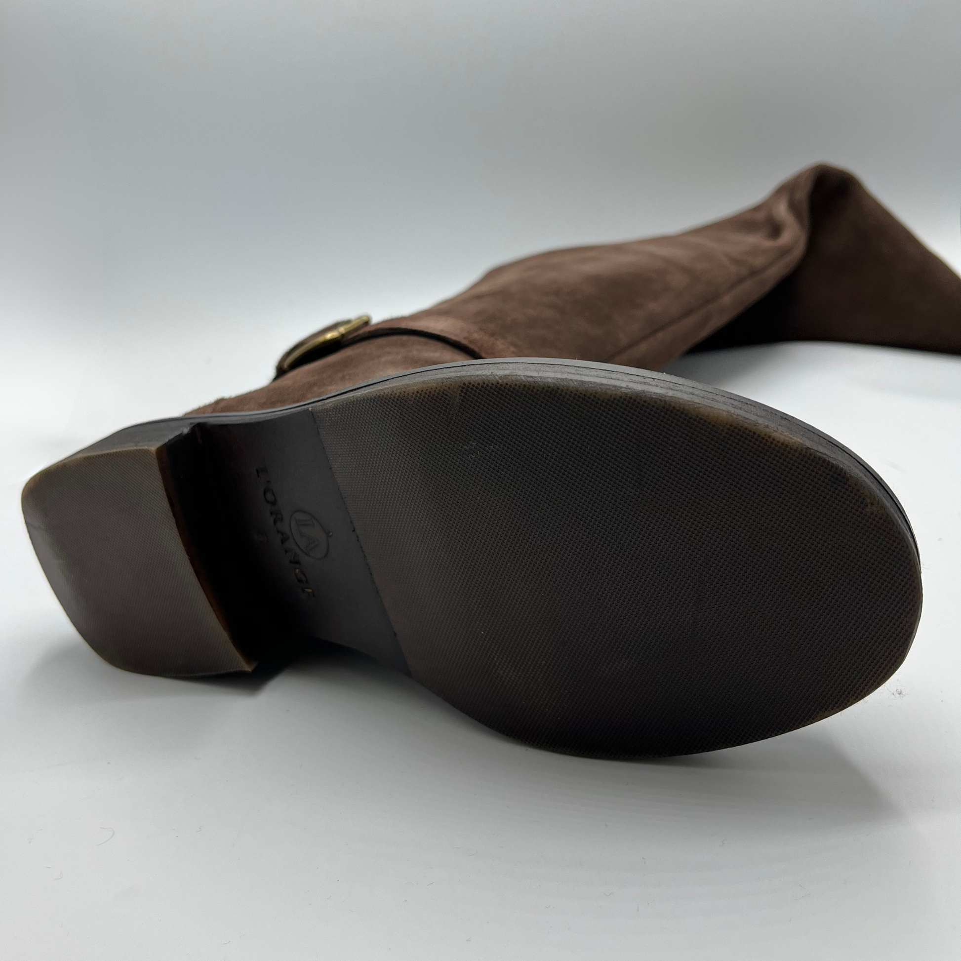 Brown suede boot with a visible brand logo on a white background