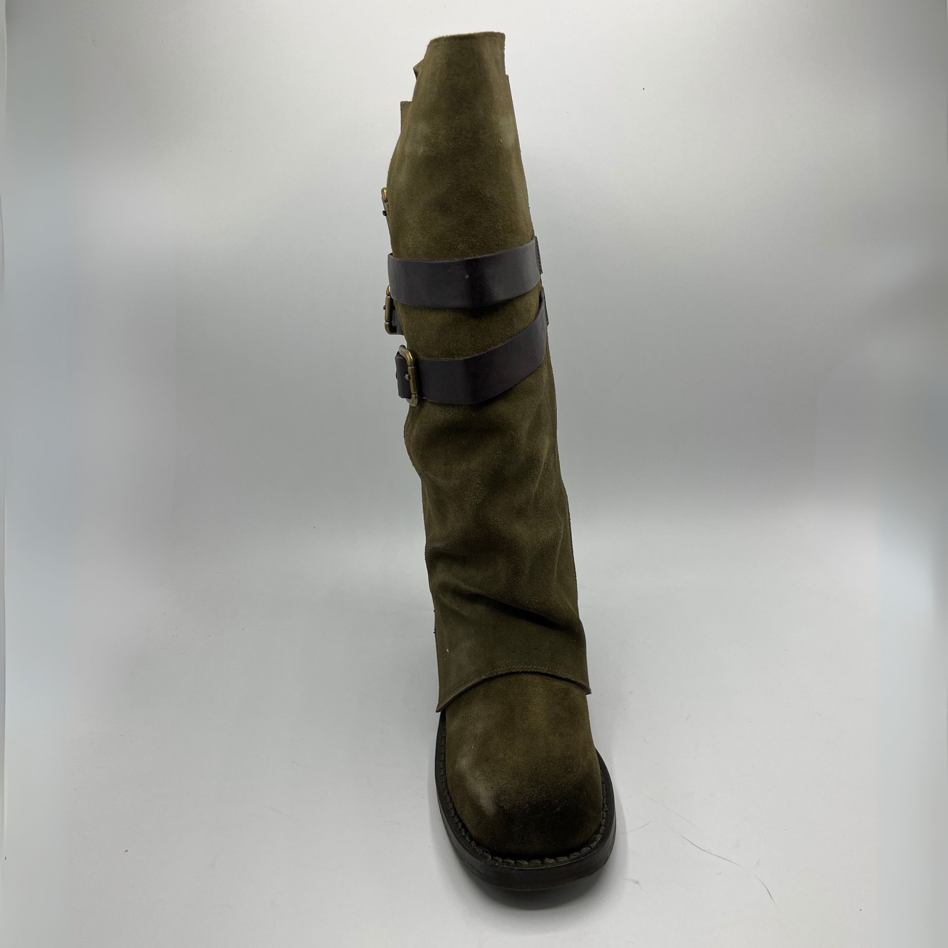 Green knee-high boot with black straps on a white background