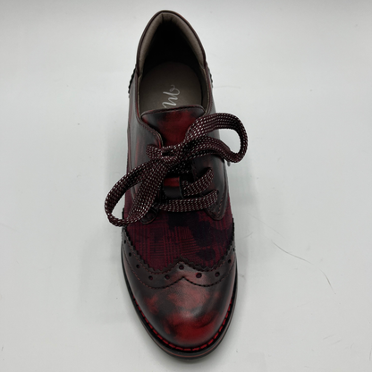Red and black brogue shoe on a white background