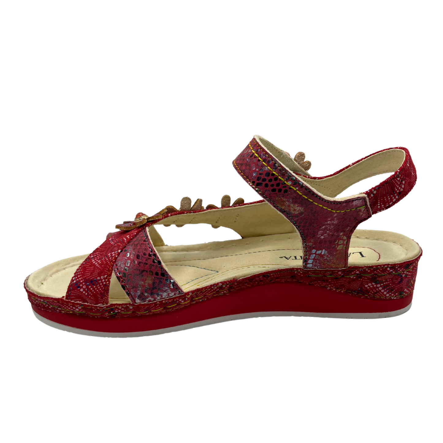 Left facing view of a red leather sandal with flower details and velcro ankle strap