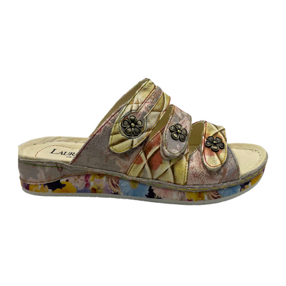 Right facing view of leather slip on sandal with low wedge heel and metal flower details on the straps