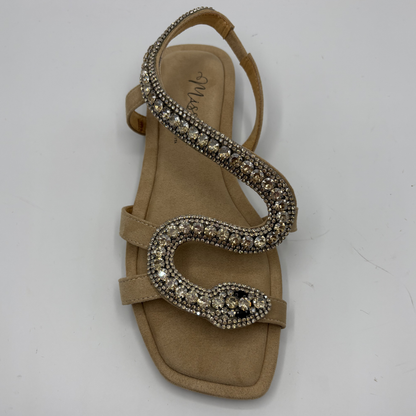 Beige sandal with decorative straps on a white background