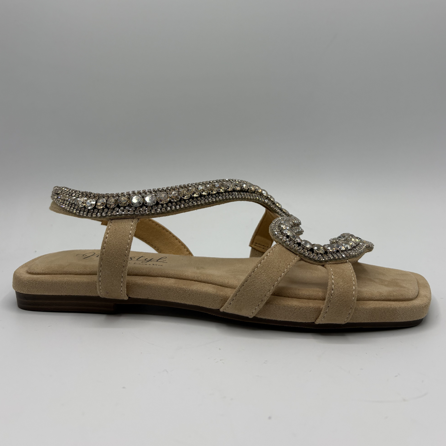 Beige sandal with decorative strap on a gray background
