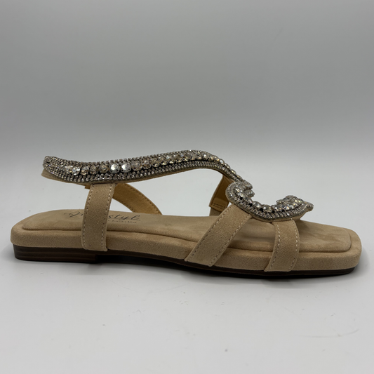 Beige sandal with decorative strap on a gray background