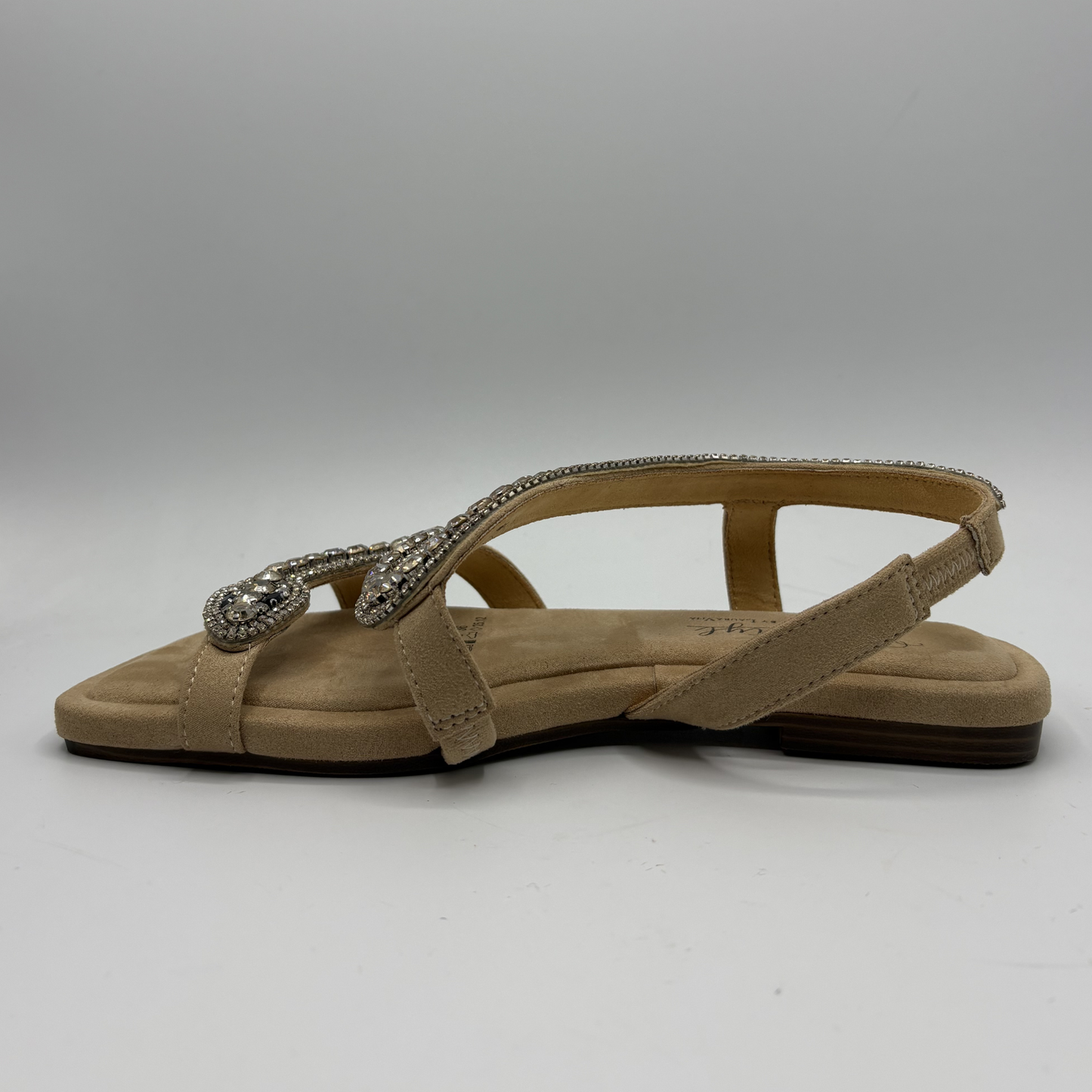 Beige sandal with a decorative strap on a gray background