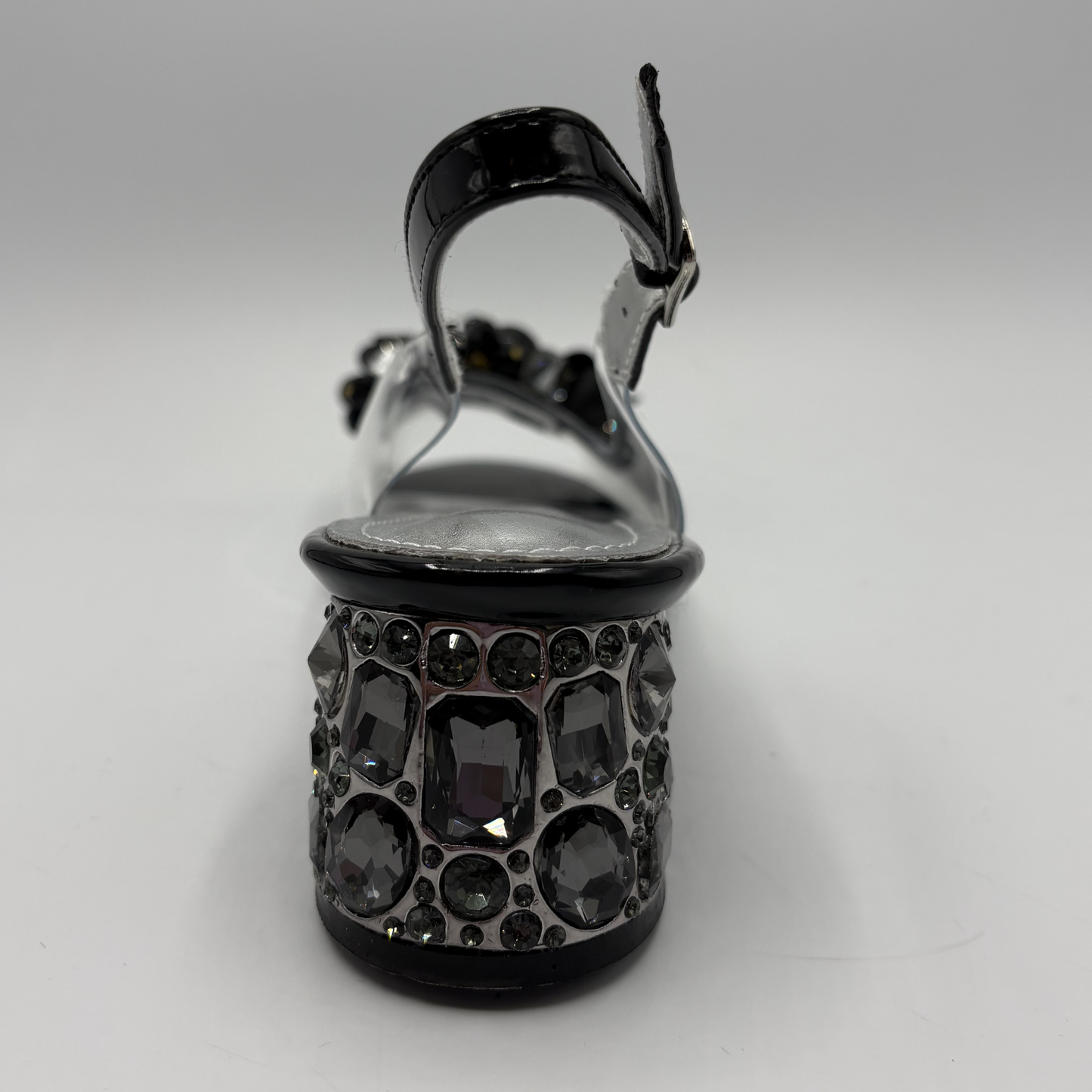 High heeled shoe with clear upper and jewelled heel on a gray background