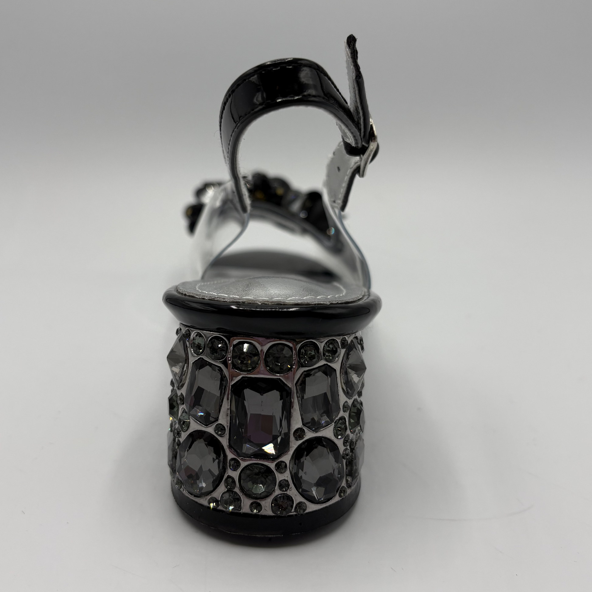 High heeled shoe with clear upper and jewelled heel on a gray background