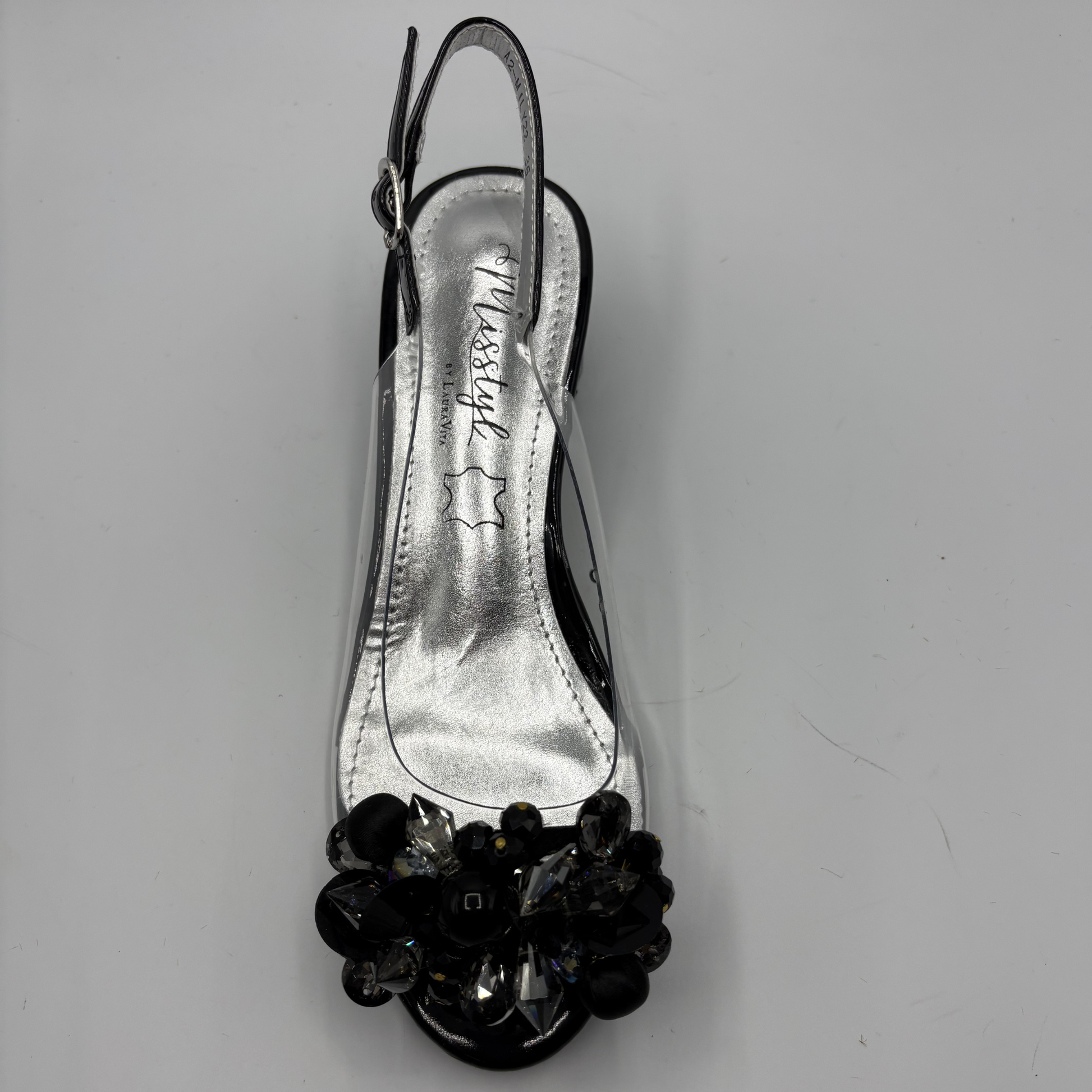 High heeled shoe with clear upper and jewelled heel on a gray background