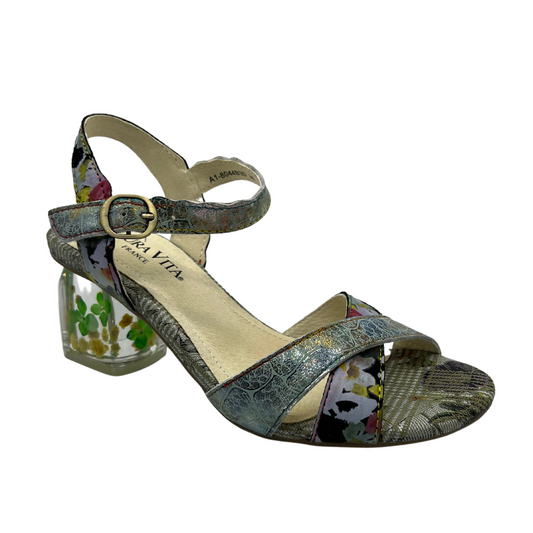 45 degree angled view of patterned leather sandal with buckle ankle strap, crossed straps on toe and block lucite heel