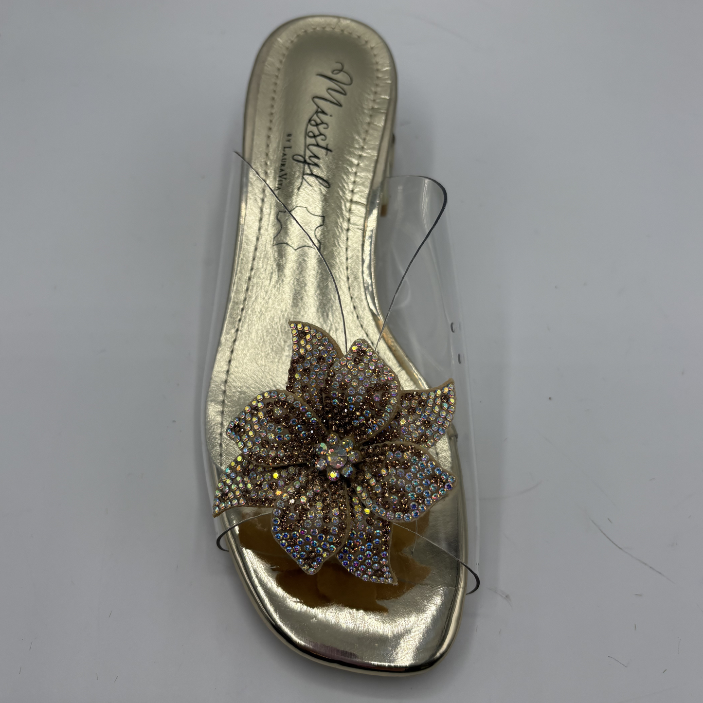 Clear sandal with decorative strap and low heel on a gray background