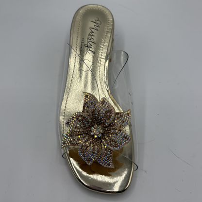 Clear sandal with decorative strap and low heel on a gray background
